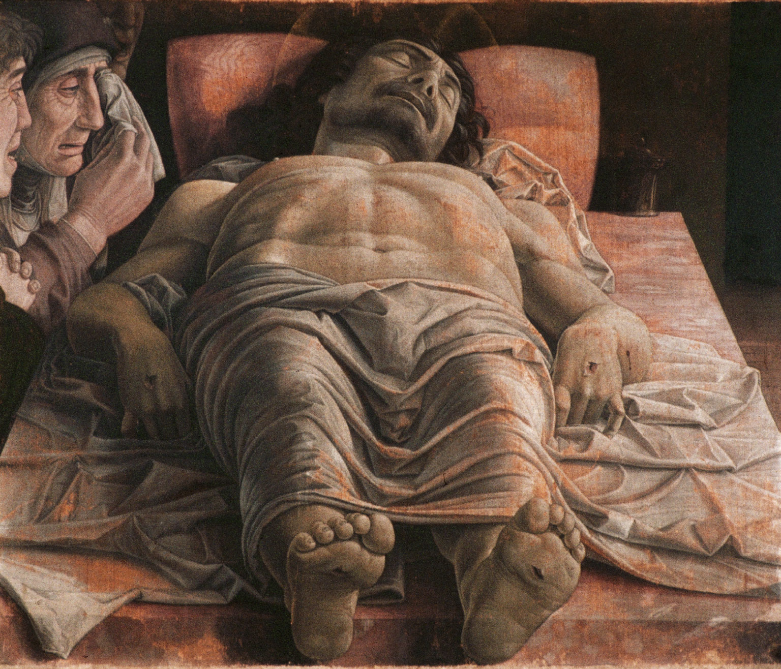 Painting of the dead Christ lying on a slab viewed feet-first, mourned by three figures